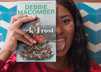Una ragazza tiene in mano un libro di Debbie Macomber