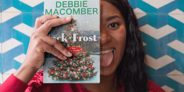 Una ragazza tiene in mano un libro di Debbie Macomber