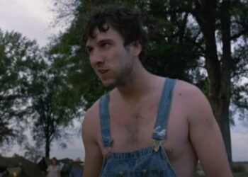 Un uomo sta in piedi con le bretelle nel film La casa dipinta